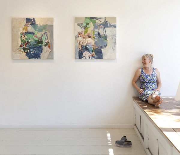 Jenny Nelson sitting with paintings